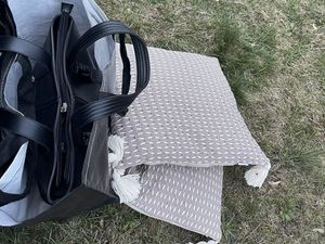 Zdjęcie przedstawia dwie poduszki oraz torebkę. To są rzeczy, które kobieta miała przy sobie