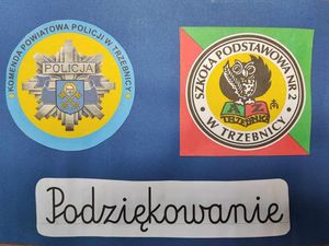 Kartka, na której znajduje się logo Komendy Powiatowej Policji w Trzebnicy oraz Szkoły Podstawowej nr 2 w Trzebnicy. Na dole znajduje się napis Podziękowanie
