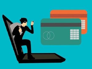 na zdjęciu widoczny złodziej ubrany na czarno wychodzący z komputera oraz dwie karty bankomatowej jedna zielona, druga pomarańczowa