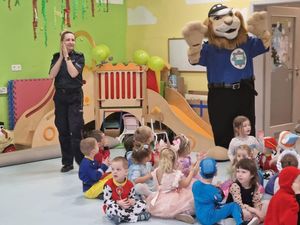 Policjantka i komisarz Lew tańczą, na podłodze siedzą dzieci.