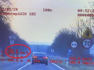 Zdjęcie z wideo rejestratora przedstawia pojazd osobowy, który przekracza dozwoloną prędkość. W dolnym prawym rogu widzimy zarejestrowaną prędkość 159 kilometrów na godzinę.