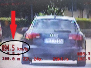 Zdjęcie przedstawia pojazd z tyłu, tablica rejestracyjna jest ukryta. W lewym dolnym rogi znajduje się prędkość 94,5 kilometra na godzinę z jaką poruszał się kierujący osobowym audi
