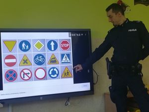 Policjant zapoznaje dzieci ze znakami drogowymi