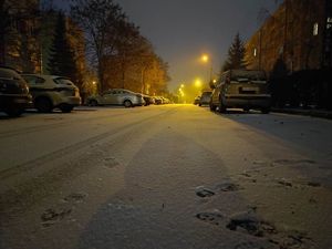 Ośnieżona ulica, a na parkingu stoją samochody