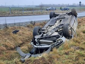 Samochód osobowy leży na dachu w rowie