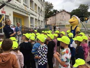 Policjantka rozmawia z dziećmi o bezpiecznym poruszaniu się po drodze.