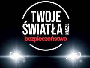 Światła samochodu na czarnym tle oraz napis Twoje Światła nasze bezpieczeństwo