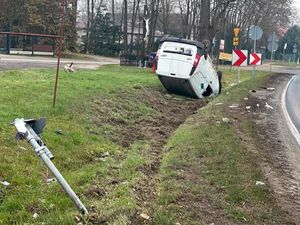 Samochód osobowy, który wypadł z drogi leży na dachu.