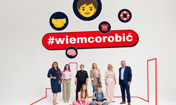 Napis #wiemcorobić pod nim znajduje się 5 kobiet w tym jedna w umundurowaniu służbowym oraz jeden mężczyzna. Ubrani są elegancko. Przed nimi siedzi dziewczynka i chłopiec. Wszyscy się uśmiechają.