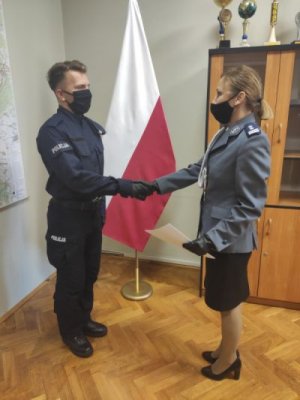 Na zdjęciu I zastępca Komendanta Powiatowego Policji w Trzebnicy młodszy inspektor Katarzyna Winter wręcza nowo przyjętemu policjantowi akt mianowania, który znajduje się w teczce z logiem komendy.