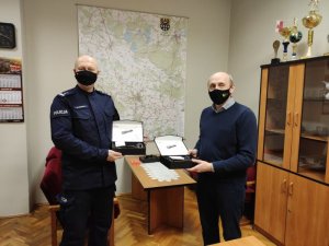 Na zdjęciu Komendant Powiatowy Policji w Trzebnicy wspólnie z sekretarzem gminy Zawonia prezentują zakupione latarki